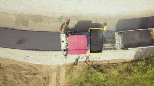 Aerial View of New Road Construction with Workers and Asphalt Laying Machinery at Work