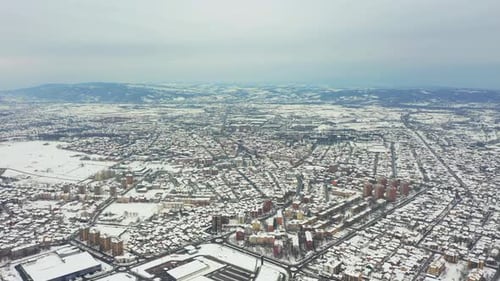 Drone flying above a typical eastern European city covered in snow