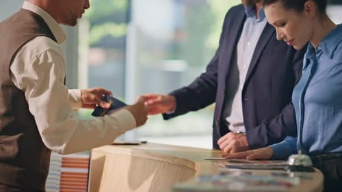 Hotel Guests Giving Passports at Desk Closeup Smiling Couple Check in on Trip