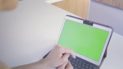 Young caucasian woman in her 30s using her tablet to be online with green screen