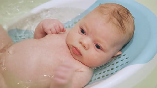 Newborn Baby Bathing in Tub Close Up