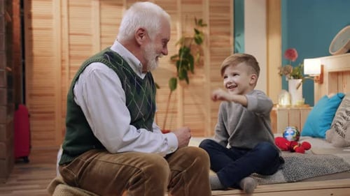 Grandfather and Grandson Laughing Together Indoors