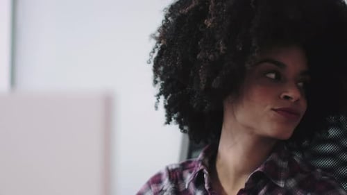 Afroamerikanische Frau arbeitet im Büro am Computer
