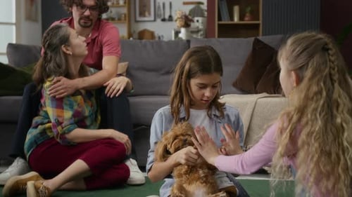 Family Plays with Cute Puppy at Home