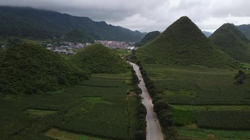 Aerial View of an Asian Village in the Mountains Surrounded By Green Forest and Rocks Rice Fields