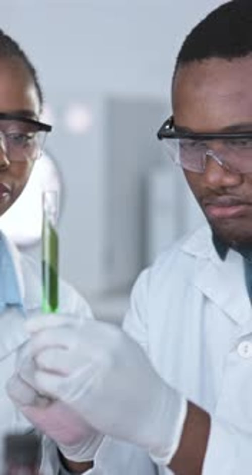 Scientists Examining Green Solution in Test Tube