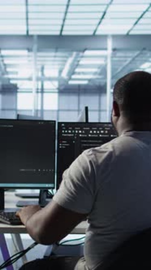 Developer Typing Code on PC to Mend Data Center Racks