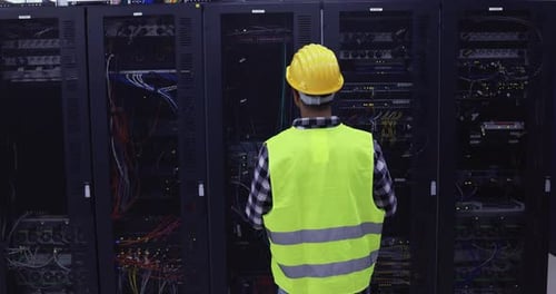Technician Man At Work Installing A New Rack Mount Server Inside Server Room