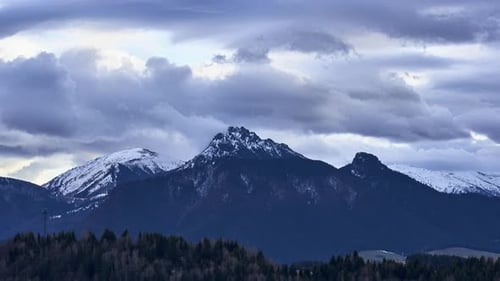 Timelapse spectaculaire du sommet d'une montagne avec des nuages d'orage se déplaçant rapidement au-dessus de la crête enneigée des Alpes
