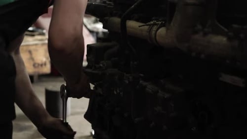 Mechanic Working on Engine With Wrench