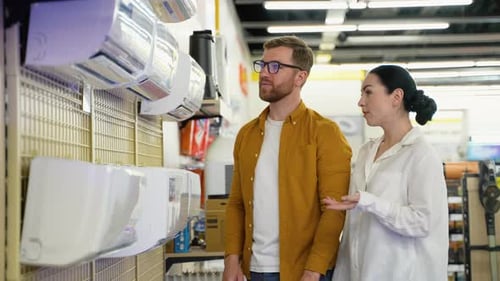 Just Married Young Couple Buying Air Conditioner in Appliances Store