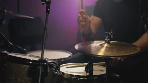 Drummer Playing Drums Under Purple Stage Lights