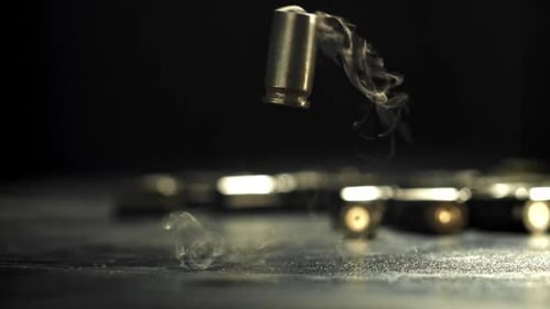 Smoking Bullet Shell Casings Falling After Gunshot