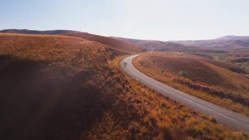 Malagasy People Walk Along a Winding Road in the Middle of the Highlands of Madagascar The Landscape