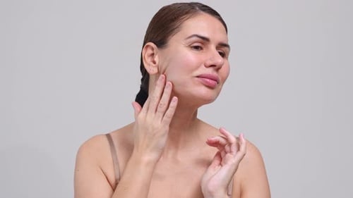 Woman Massages Face and Neck for Skin Care
