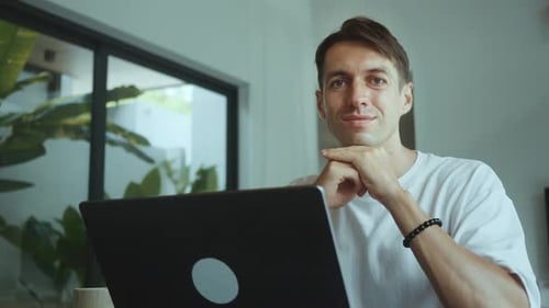 Man Working on Laptop at Home Smiling