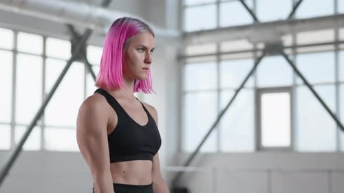 Woman Does Bicep Curls in Bright Gym