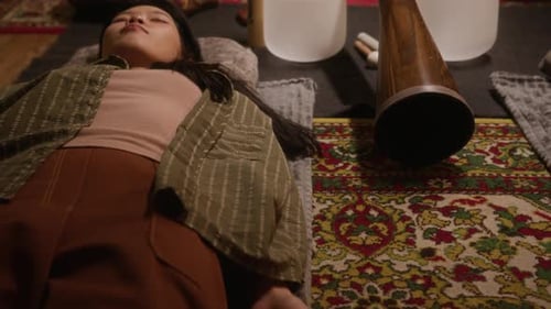 Asian Girl Lying in Shavasana during Sound Meditation Therapy Session