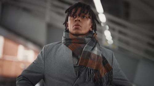 Outdoors Portrait of Worried Young Black Man with Smartphone in Urban Landscape African American