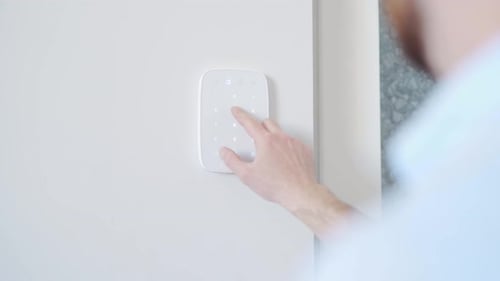 Adult Using Smart Home Security System Keypad