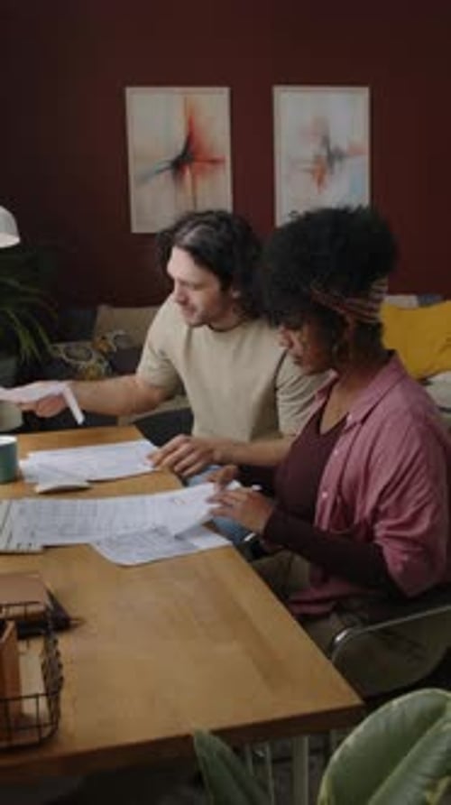 People Reviewing Documents Together at Wooden Table