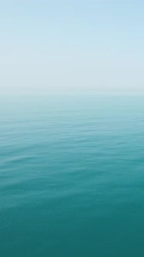 Vertikale Luftaufnahme über ruhigem azurblauem Meerwasser, Sonnenblendung, abstrakter nautischer Sommerozean