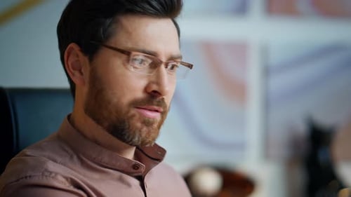 Happy middle-aged businessman talking at business conference in modern office