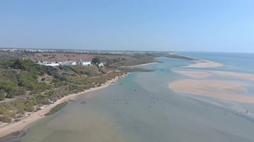 Aerial view of small village surrounded by beautiful bay where the river flows into the ocean.