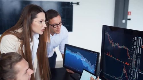 Team of stockbrokers works together in modern office at daytime