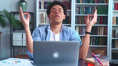 Young Adult Meditating at Desk with Laptop
