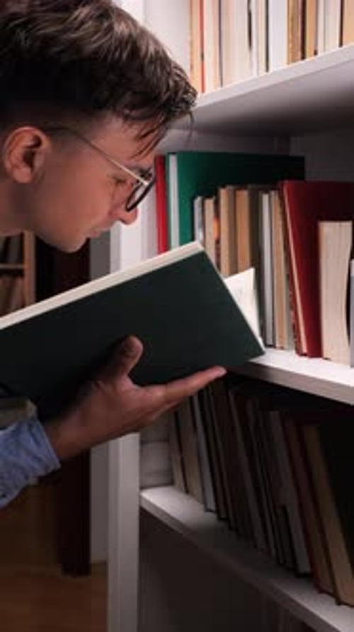 Vertical Video Researcher Reading a Book in the Library Surrounded By Knowledge