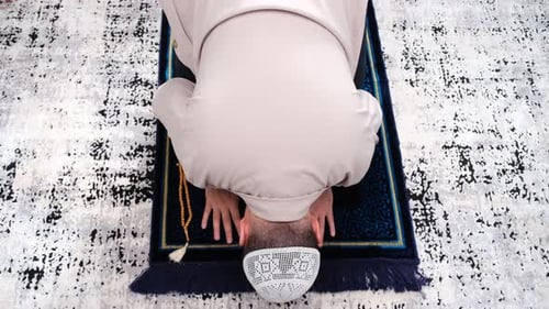 Man Praying on a Rug in a Religious Practice