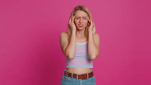 Blonde Woman Suffering Headache in Bright Studio
