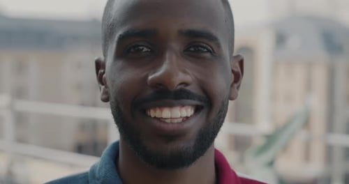 Closeup Portrait of Smiling African American Student Against City Background