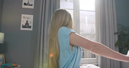 Linda jovem olhando para a câmera sentada na cama posando sozinha em casa Mulher atraente