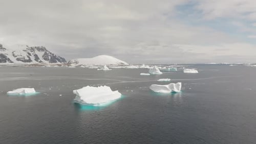 Iceberg flutuando no oceano Ártico com uma enorme plataforma de gelo no horizonte, vista aérea