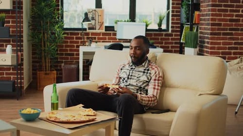 Young Adult Eating Pizza at Home