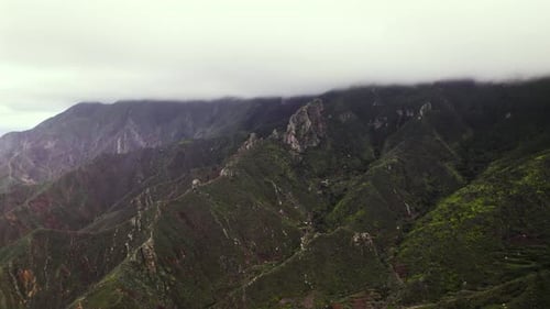 Aerial view of green volcanic rocky mountain ridge in Tenerife, background