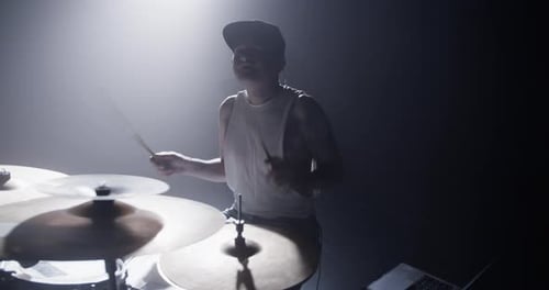 Un baterista masculino feliz interpretando una canción en una batería