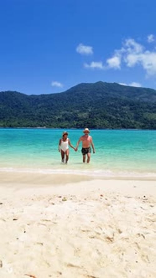 a Man and a Woman are Walking Out of the Ocean on a Beach Koh Lipe Thailand