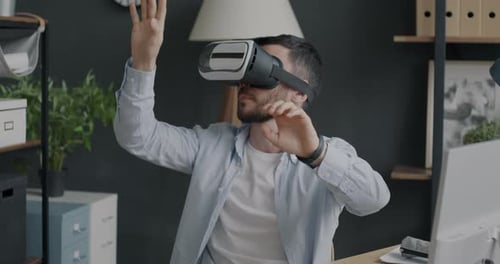 Portrait of Male Employee Wearing Virtual Reality Glasses Relaxing in Office During Break