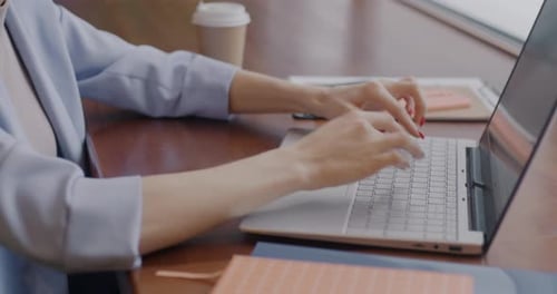 Young Adult Typing on a Laptop at Work
