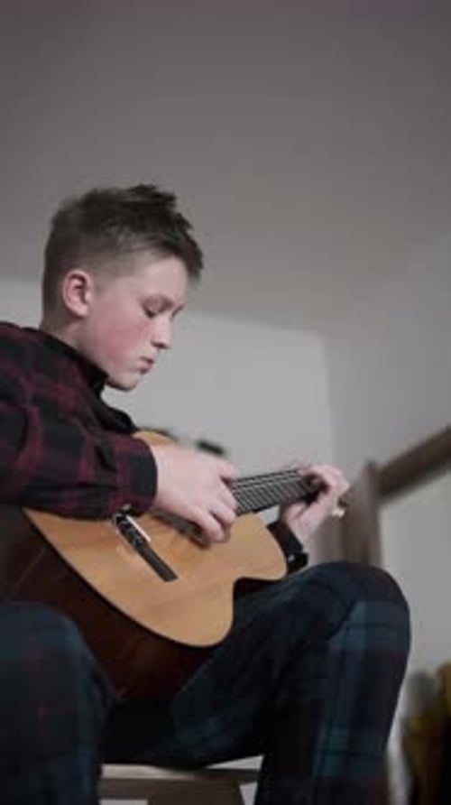 Boy Playing Guitar in Home