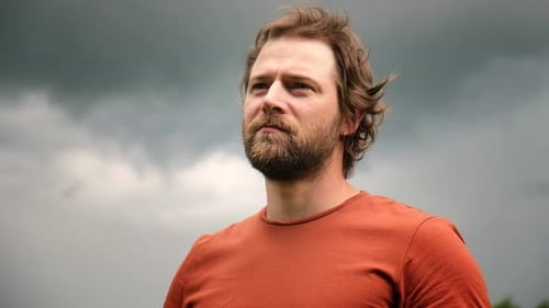 Man Looking at Cloudy Sky in Natural Setting