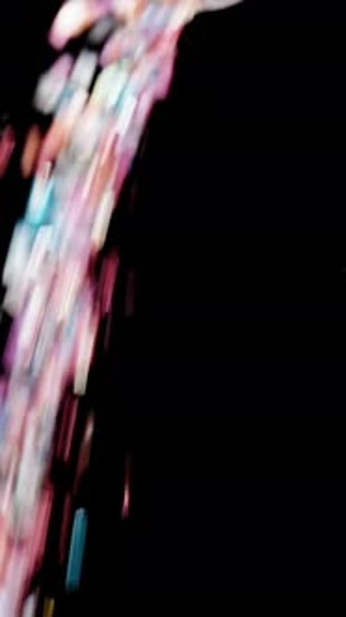 Vertical video. Multicolored Sprinkles and Sugar Crystal Particles Pour from above like a Sweet Rain