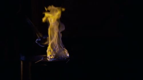 Flames Burning Yellow and Blue Liquid at Night