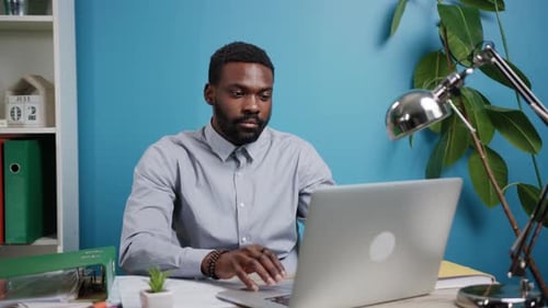 A Focused and Dedicated Professional Engaged in Work on a Laptop in a Contemporary Office Space