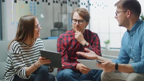 Junge Frau und zwei männliche Kollegen treffen sich freundlich und diskutieren über neue Geschäftsideen. Ea