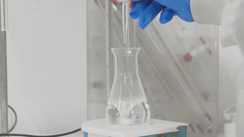 chimiste scientifique effectuant un test en laboratoire. verser un liquide qui change de couleur en violet un