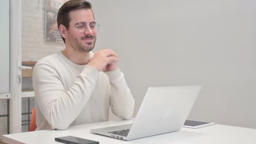 Middle Aged Man Doing Video Chat on Laptop in Office